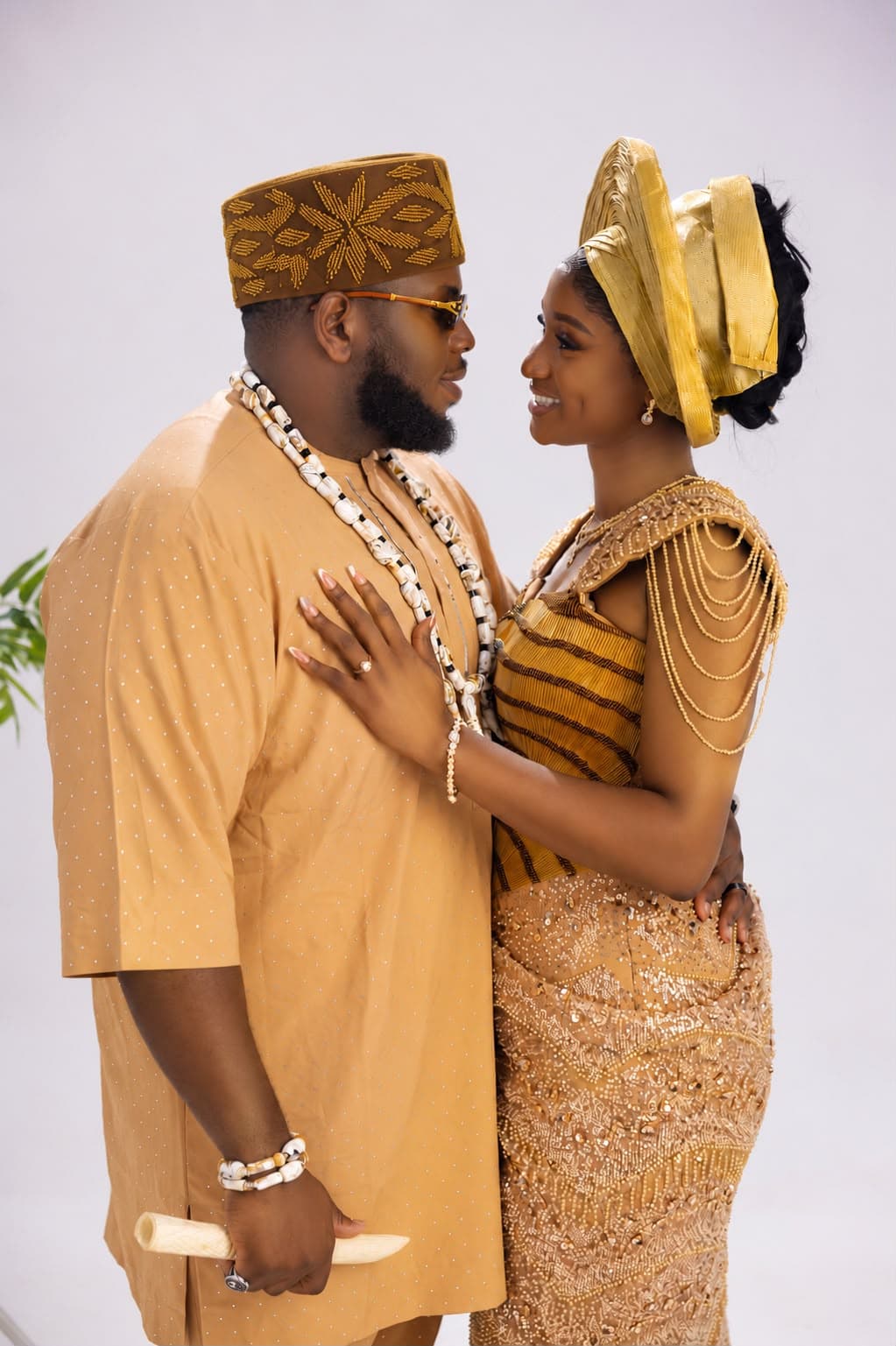 Ifeanyi and Gabrielle smiling together in gold traditional attire