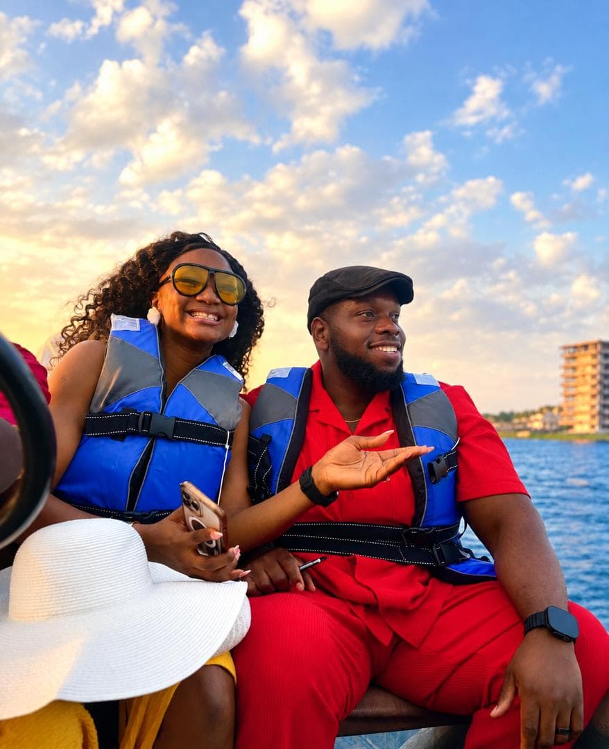 Gabrielle and Ifeanyi smiling together by the lake at sunset